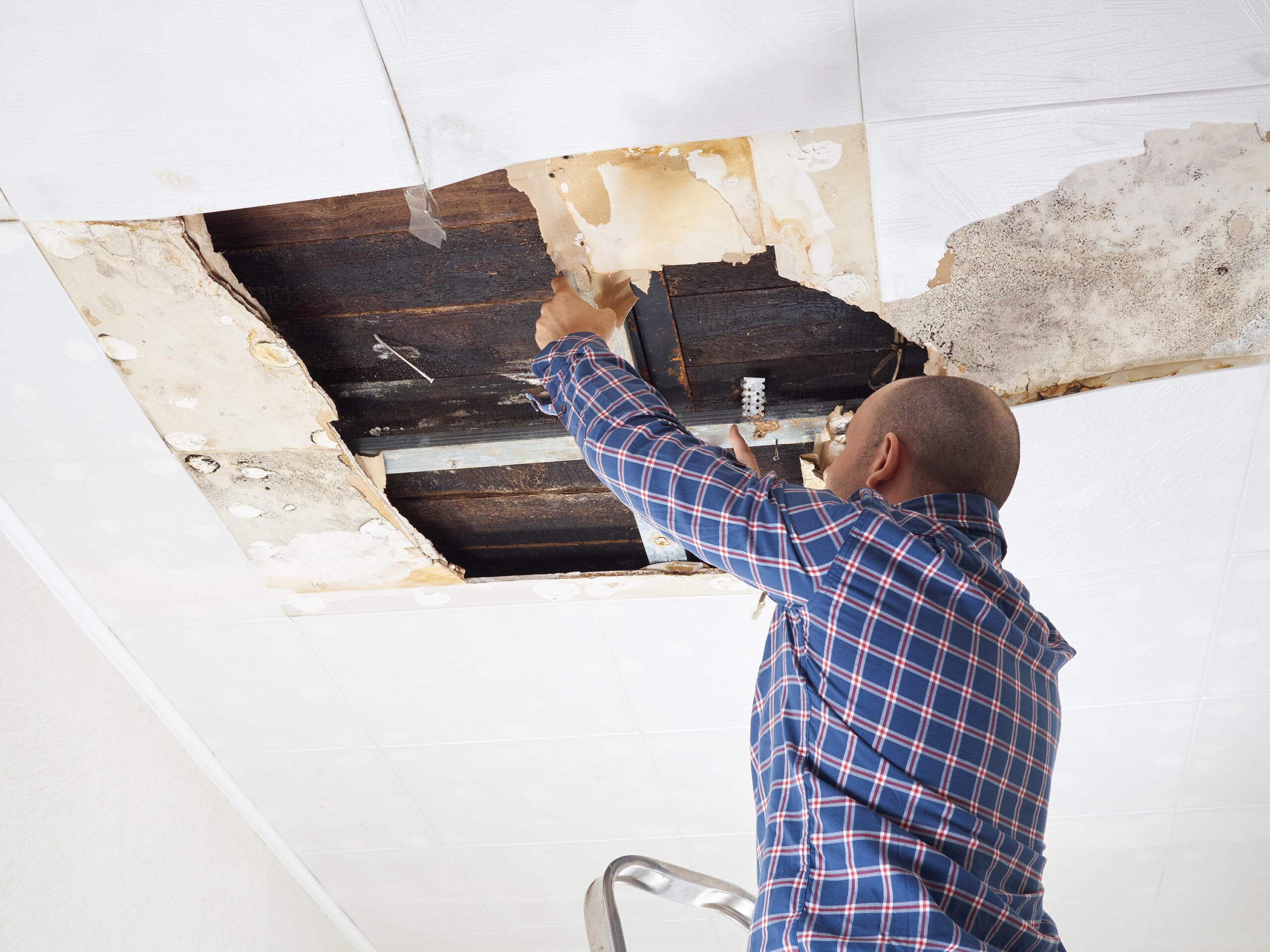 Man repairing collapsed ceiling.